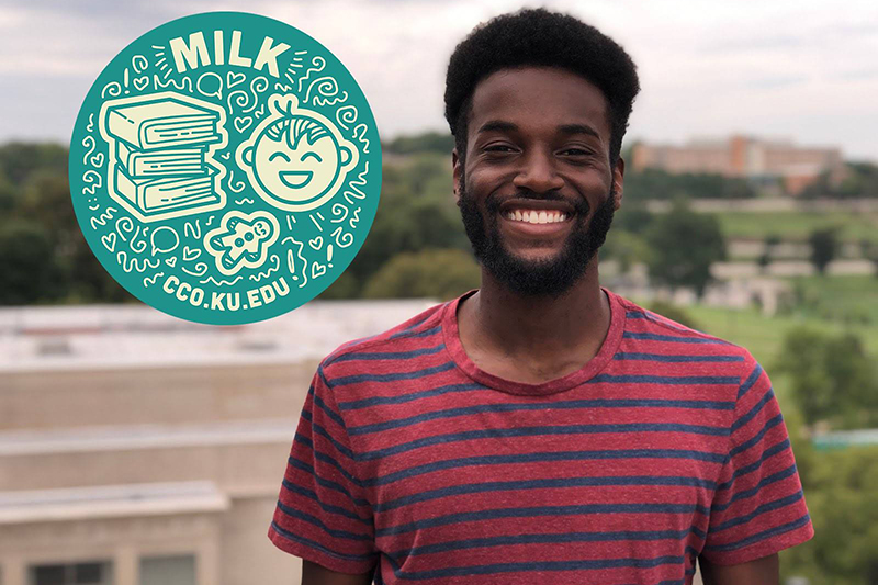 Smiling Black male student with KU campus in background.